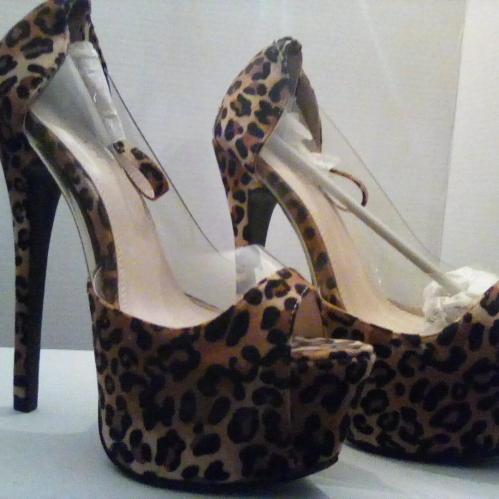Size 8 animal print in worn platforms with unwrapped ankle straps.